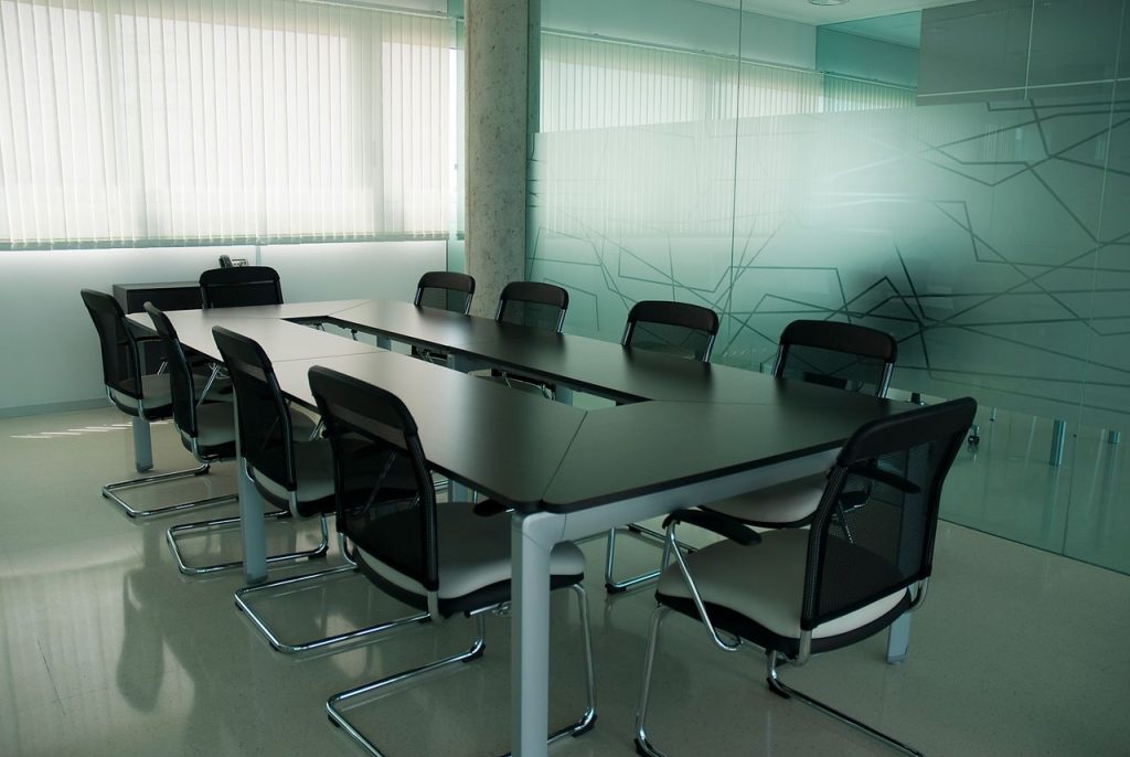 Elegant conference room with sleek black chairs and a modern glass wall design.